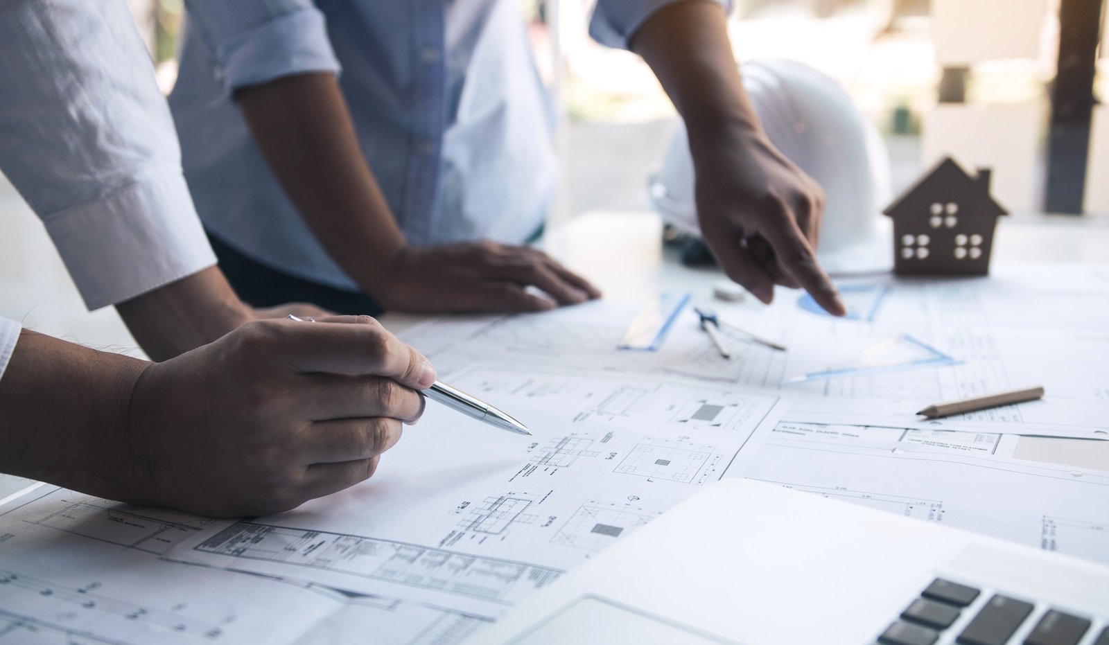 Structural engineering designers are working on the blueprints and analyzing them together.