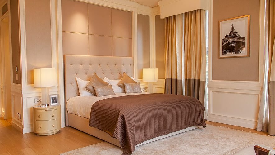 residence_bedroom Supremely comfortable bedroom featuring a plush bed with brown bedding, elegant bedside lamps, and modern decor, reflecting Rizo Homes' commitment to luxury living.
